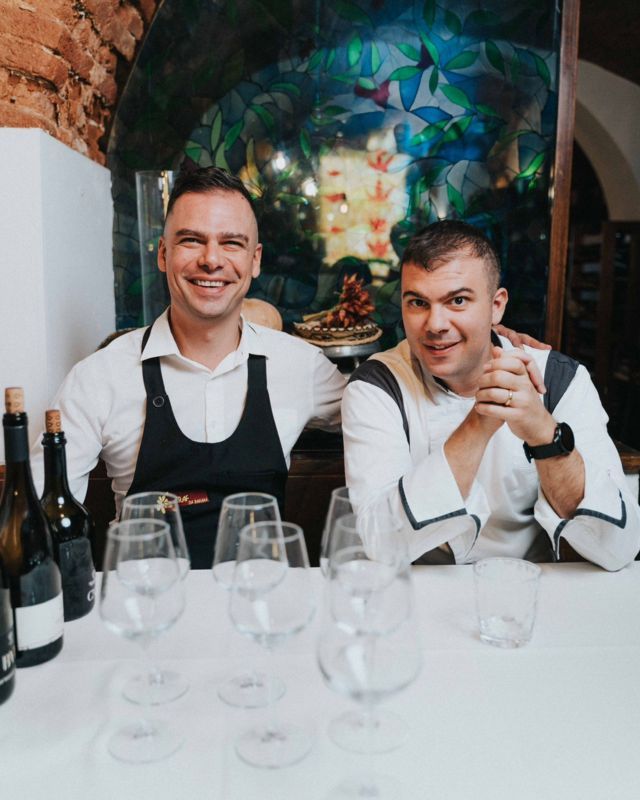 mangiare giovane a oristano alberto e mattia del ristorante craf seduti a un tavolo in posa con bottiglie di vino
